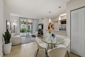 Doral apartment for rent - A modern dining room with a glass table and white chairs.