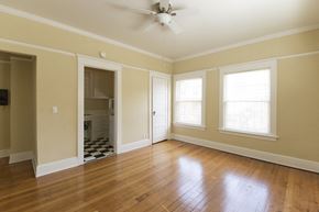 Portland apartment for rent - an empty living room with wood floors and a ceiling fan