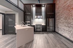 Evansville apartment for rent - A modern kitchen with a brick wall and wooden floors.