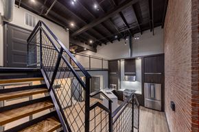 Evansville apartment for rent - A staircase with a metal railing leads to a kitchen area.