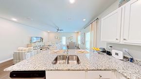 Orange Beach townhouse for rent - A kitchen with a granite countertop and a fan on the ceiling.