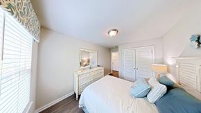 Orange Beach townhouse for rent - A bedroom with a bed, dresser, and mirror.