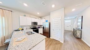 Orange Beach townhouse for rent - A kitchen with granite countertops and white cabinets.