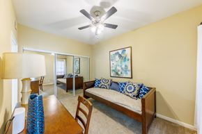 Biloxi apartment for rent - A bedroom with a bed, a chair, a table, and a ceiling fan.