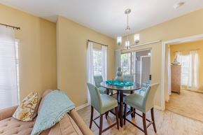 Biloxi apartment for rent - A dining room with a table set for four and a couch with a throw pillow.