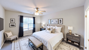 Chattanooga apartment for rent - A bedroom with a bed, nightstand, chair, and pictures on the wall.