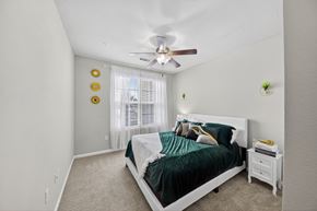 Lake Charles apartment for rent - A bedroom with a bed, nightstand, and a ceiling fan.