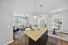 Lake Charles apartment for rent - A kitchen with a granite countertop and a dining area with a white table and chairs.