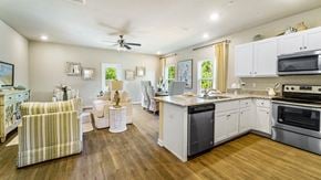 Orange Beach townhouse for rent - A well-lit kitchen with a striped armchair and a dining table with chairs.