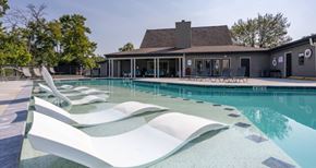 Chattanooga apartment for rent - A pool with a white lounger in the foreground and a house in the background.