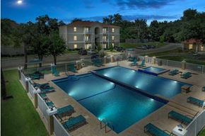 Long Beach apartment for rent - A large swimming pool surrounded by lounge chairs and a building in the background.
