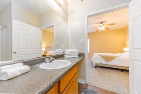Long Beach apartment for rent - A bathroom with a sink, mirror, and a bedroom in the background.