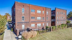 Evansville apartment for rent - A red brick building with a black fence in front.