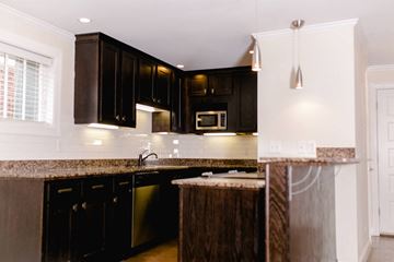 Evansville apartment for rent - A kitchen with black cabinets and a granite countertop.