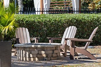 Two chairs and a table are in front of a hedge