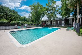 North Charleston apartment for rent - A swimming pool surrounded by a fence and trees at Brackenbrook Apartments, North Charleston, South Carolina