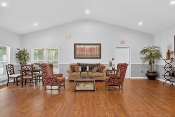 North Charleston apartment for rent - A living room with a large painting on the wall and a variety of chairs and a coffee table.