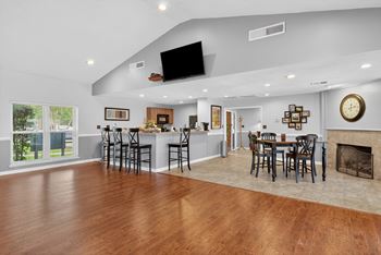 A modern open floor plan with a bar area and a fireplace.