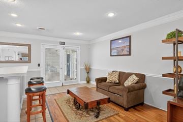 Hanahan townhouse for rent - A living room with a brown couch, a wooden coffee table, and a painting on the wall.