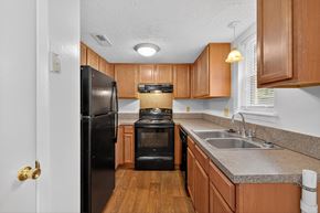Moncks Corner apartment for rent - A kitchen with a black refrigerator and stove at Woodlocke Apartments, South Carolina