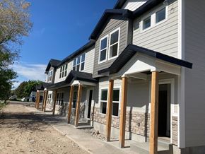 Preston townhouse for rent - A row of houses under construction with grey siding and white trim.
