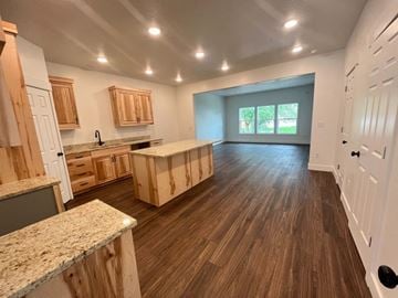 Preston townhouse for rent - A kitchen with wooden cabinets and a countertop is shown.