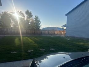 Preston townhouse for rent - A car is parked in front of a house with a wooden fence and trees in the background.