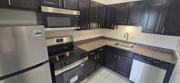 Shorewood apartment for rent - A kitchen with black cabinets and stainless steel appliances.