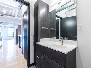 Racine apartment for rent - A bathroom with a sink, mirror, and cabinets.