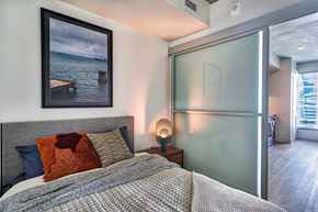 Oakland apartment for rent - A bedroom with a bed, nightstand, and a picture on the wall.at Eleven Fifty Clay Street, Oakland, CA  