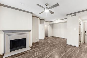 A room with a fireplace and a ceiling fan.