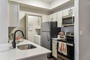 Austin apartment for rent - A kitchen with a black refrigerator and white countertops.at Onyx183, Austin, TX  