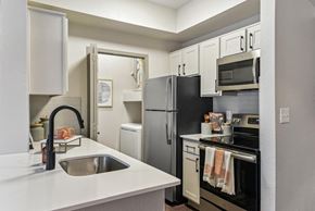Austin apartment for rent - A kitchen with a black refrigerator and white countertops.at Onyx183, Austin, TX  
