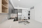Los Angeles apartment for rent - A modern kitchen with a stainless steel refrigerator and a sink at Coro Apartments, California 90016