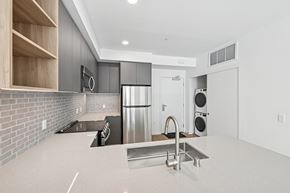 Los Angeles apartment for rent - A modern kitchen with a stainless steel refrigerator and a sink at Coro Apartments, California 90016