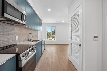 Los Angeles apartment for rent - A modern kitchen with dark blue cabinets and a white stove top oven.