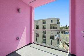 Los Angeles apartment for rent - A pink wall with a window overlooking a building.