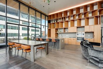A modern kitchen with a long table and chairs.