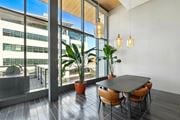 Oakland apartment for rent - A modern dining area with a table, chairs, and potted plants.at Channel House, Oakland, CA