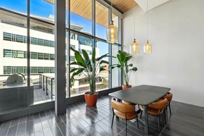 Oakland apartment for rent - A modern dining area with a table, chairs, and potted plants.at Channel House, Oakland, CA