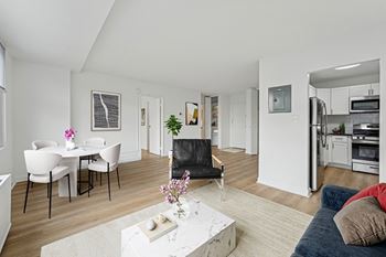 A modern living room with a dining table and chairs.