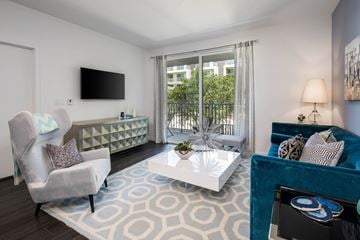 Santa Monica apartment for rent - A living room with a grey chair, a white coffee table, and a blue couch.