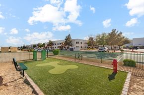 Las Vegas apartment for rent - A playground with a green bench, a red fire hydrant, and a tennis court.