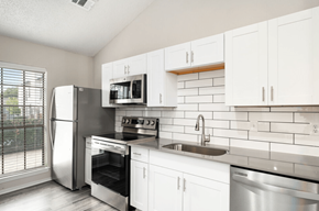 Dallas apartment for rent - A kitchen with white cabinets and stainless steel appliances.