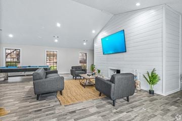 Dallas apartment for rent - A living room with a pool table and a television mounted on the wall.