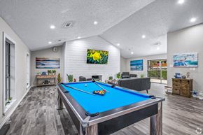 Dallas apartment for rent - A pool table is in the middle of a room with a couch and a painting on the wall.