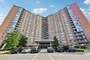 Alexandria apartment for rent - A large red brick hotel with a parking lot in front.