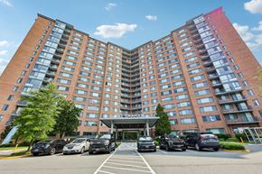 Alexandria apartment for rent - A large red brick hotel with a parking lot in front.