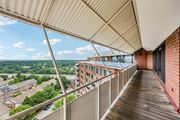 Alexandria apartment for rent - A balcony with a metal railing overlooks a parking lot and buildings.
