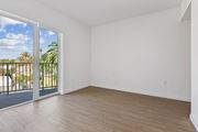 Los Angeles apartment for rent - A room with a sliding glass door leading to a balcony with a view of a fence and trees.
